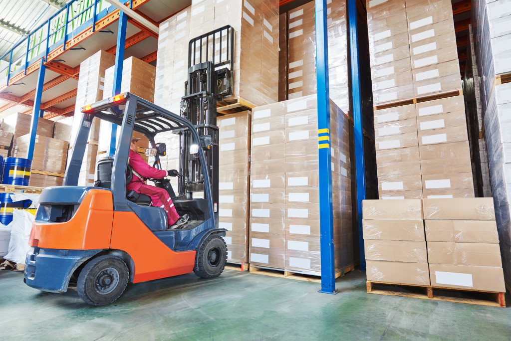 a man driving a forklift about to carry a product