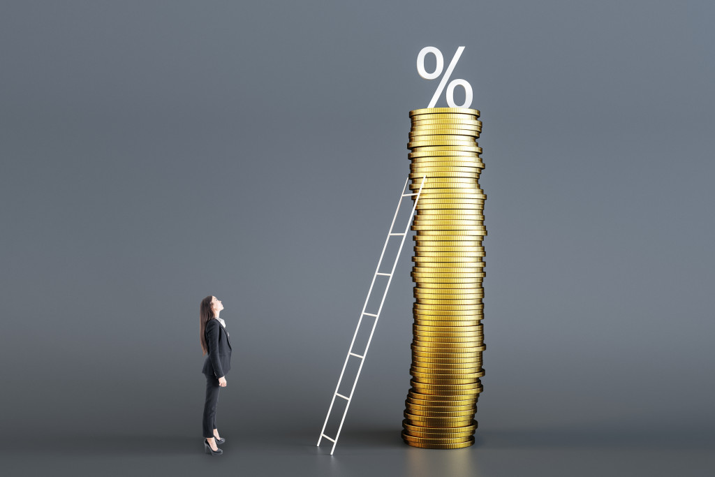 young woman facing a stack of coins