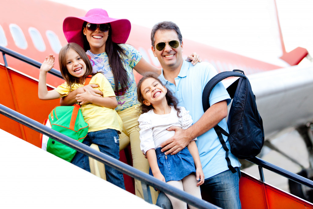 a happy family of four about to ride a plane